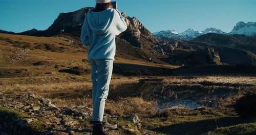 Woman Takes Photos of Majestic Mountains with Smartphone