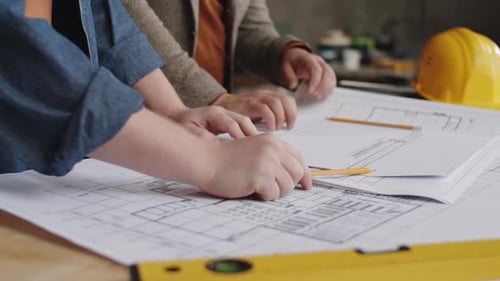 Architects Reviewing Blueprints in Workplace