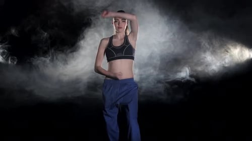 Young Woman Practicing Karate Moves in Dramatic Lighting