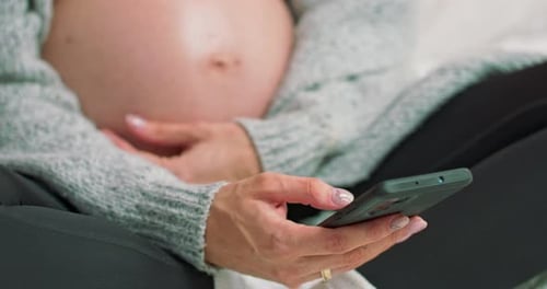 Pregnant Woman Holding Phone Resting Hands on Belly