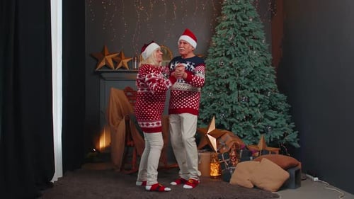 Senior Couple Dancing at Christmas by Decorated Tree