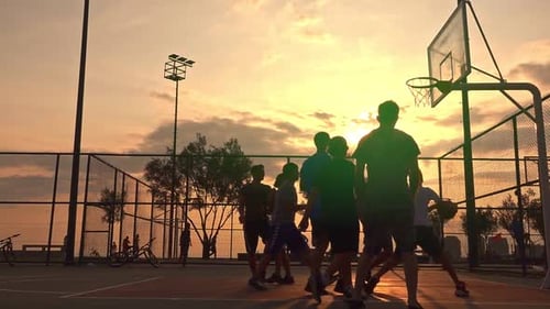 Young Adults Playing Basketball at Sunset