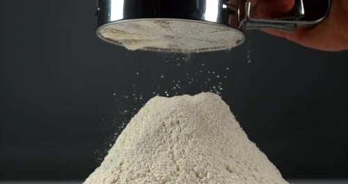 Flour Sifting Over a Pile of Flour