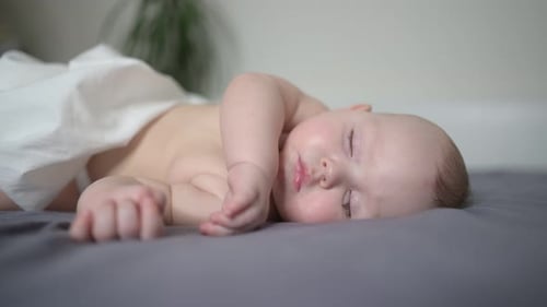 Infant Sleeping Soundly on a Gray Blanket