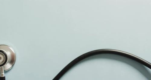 Video of close up of stethoscope with heart on blue background