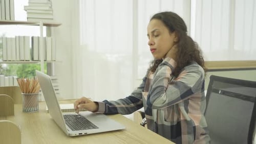 Woman at Laptop Massages Stiff Neck