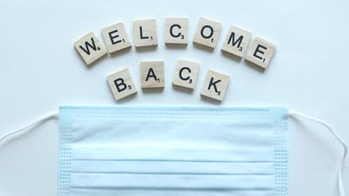 phrase welcome back composed from wooden letters covered by mask