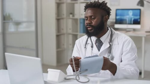Doctor Demonstrates Blood Pressure Device During Telehealth Consultation