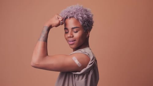 Woman Smiles with Bandage on Arm After Vaccination