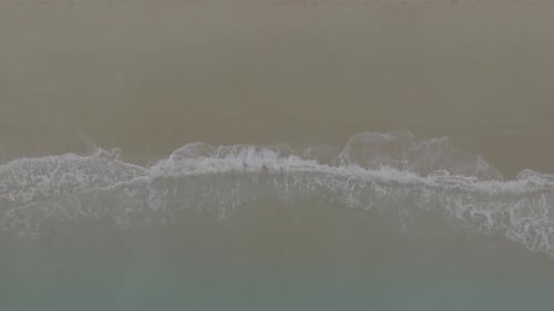 Aerial View of Waves Washing onto Sandy Beach