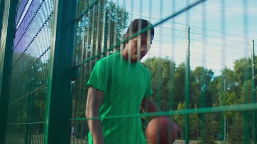 Skillful Streetball Player Dribbling Ball on Court