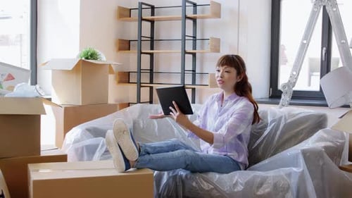 Woman Video Calling with Tablet in New Home