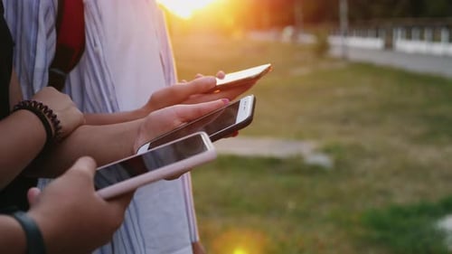 Three Persons Use Smartphones on the Street