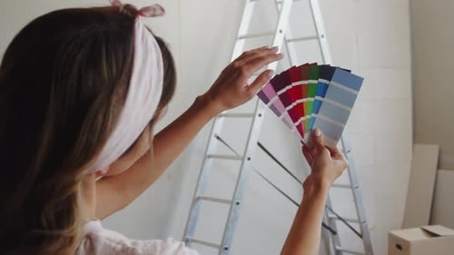 Woman Chooses Paint Swatches for Home Renovation