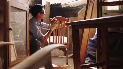 Carpenter working on woodworking machines in carpentry shop