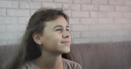 Girl Sits Calmly by Rainy Window
