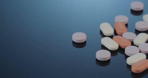 Pills Spread on Dark Blue Reflective Surface