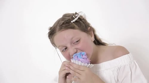 Girl Enjoys Colorful Cupcake in Studio Setting