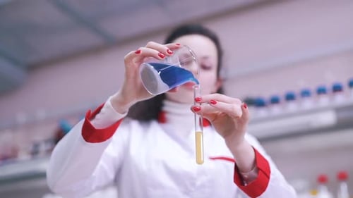 Woman Scientist Pouring Blue Liquid into Test Tube