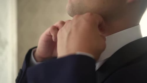 Young Adult Adjusting his Bow Tie