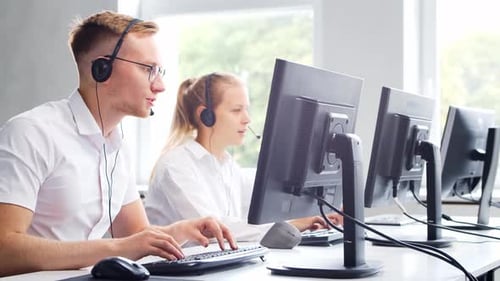 Diverse team of young professionals is working in the phone support office.