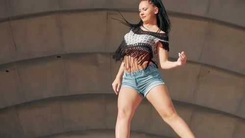 Tanzende Weibliche. glückliche Frau mit gemischter Rasse tanzt Performance mit langen Dreadlocks in kurzen Hosen