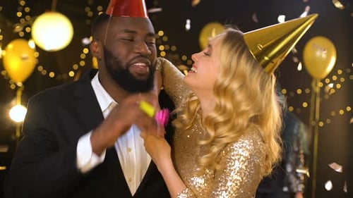 Glad Mixed-Race Couple in Party Hats Celebrating Birthday, Holiday Entertainment