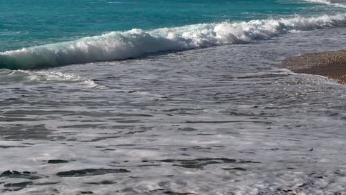 Turquoise Ocean Waves Lapping on Grainy Beach