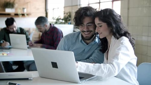 Team Collaborating on Laptop in Bright Modern Office