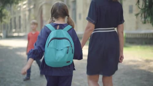 Die
Kamera folgt dem brünetten kleinen Mädchen, das mit einer unkenntlichen Mutter auf dem sonnigen Schulhof geht.
Zurück