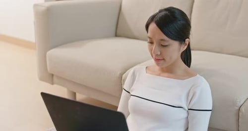 Woman Using Laptop Computer Sitting in Home Interior