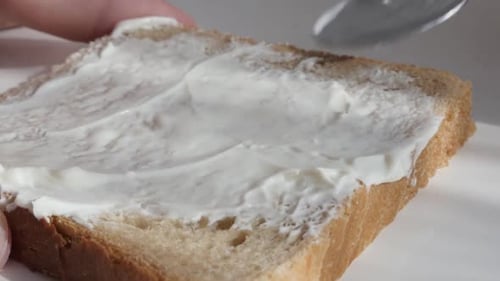 Spreading Cream Cheese on Bread Slice for Breakfast