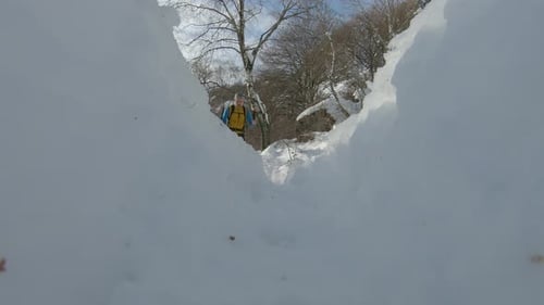 Hiker walking with poles through snow in Dolomite Alps, Italy