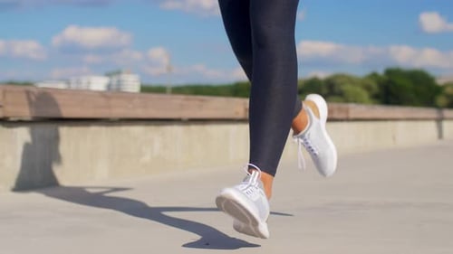 Woman Jogging in Black Leggings and White Shoes