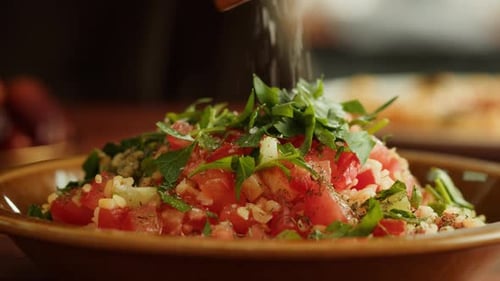 Adding Seasoning to a Colorful Vegetable Salad
