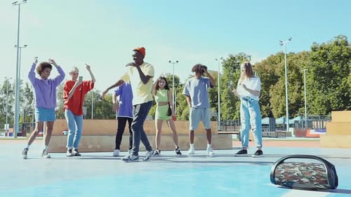 Young People Dancing Together Outdoors in Urban Park