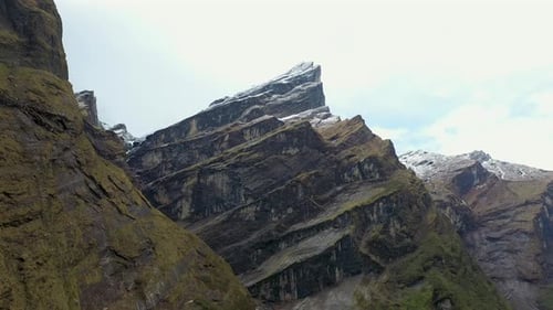Rotating aerial shot of a large rock face coming out of the ground in the Annapurna mountains, Nepal