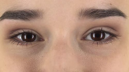 Brown Female Eyes Looking Straight and Smiling. Close Up