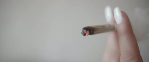 Nahaufnahme einer Frau, die einen Cannabis-Joint raucht, Zeitlupe
