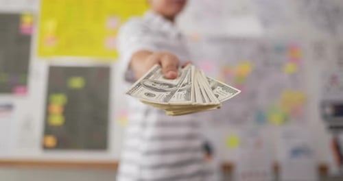 Close Up of Hand Passing Stack of Money