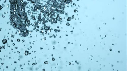 Abstract Footage of Water Droplets Against Pale Blue