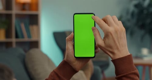 Caucasian Man Scrolling on Chroma Key Screen of Smartphone