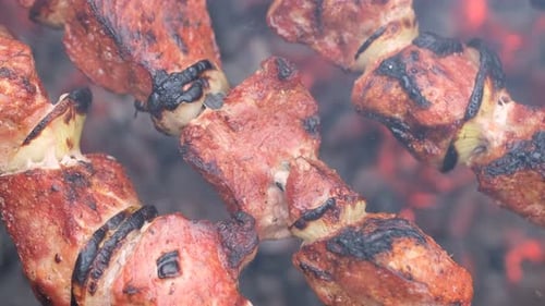 Meat Skewers on Grill Above Burning Coals