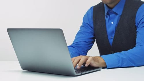 Person Typing on Laptop at Desk in Office