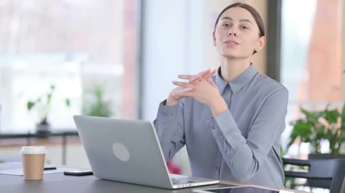 Smiling Woman Working on Laptop in Office