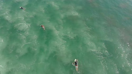 Surfers Relaxing in Turquoise Ocean Water Aerial View