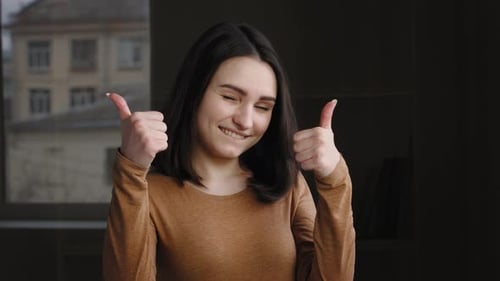 Enthusiastic Woman Gives Two Thumbs Up to Camera