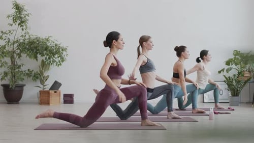 Women Practicing Yoga in Bright Studio