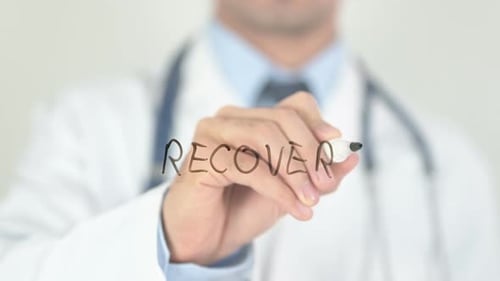 Doctor Writes Word Recovery on Clear Surface