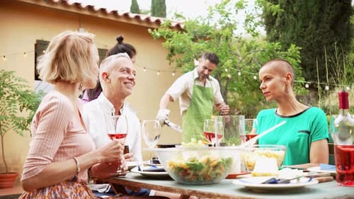 Adults Enjoying Outdoor Meal and Socializing